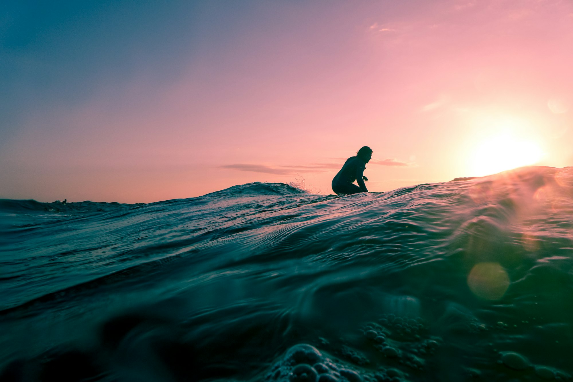 Surfer waiting on a wave at dusk